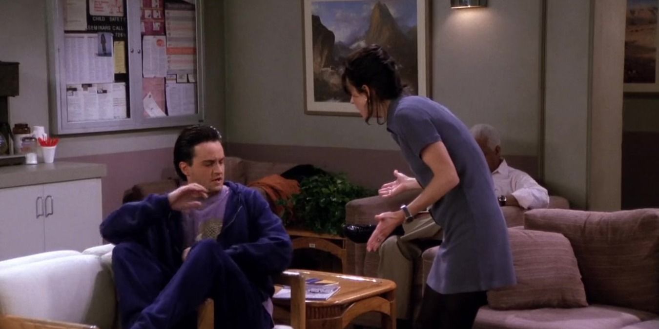 Chandler sitting on the chair in the hospital waiting room with Monica standing over him in Friends