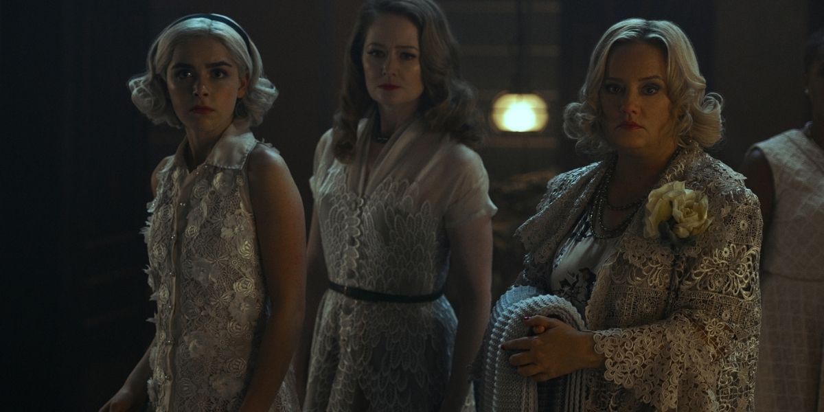 Hilda, Zelda, and Sabrina standing next to each other dressed in white