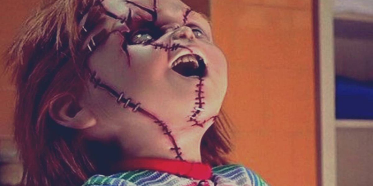 Chucky with head titled up laughing in Child's Play franchise