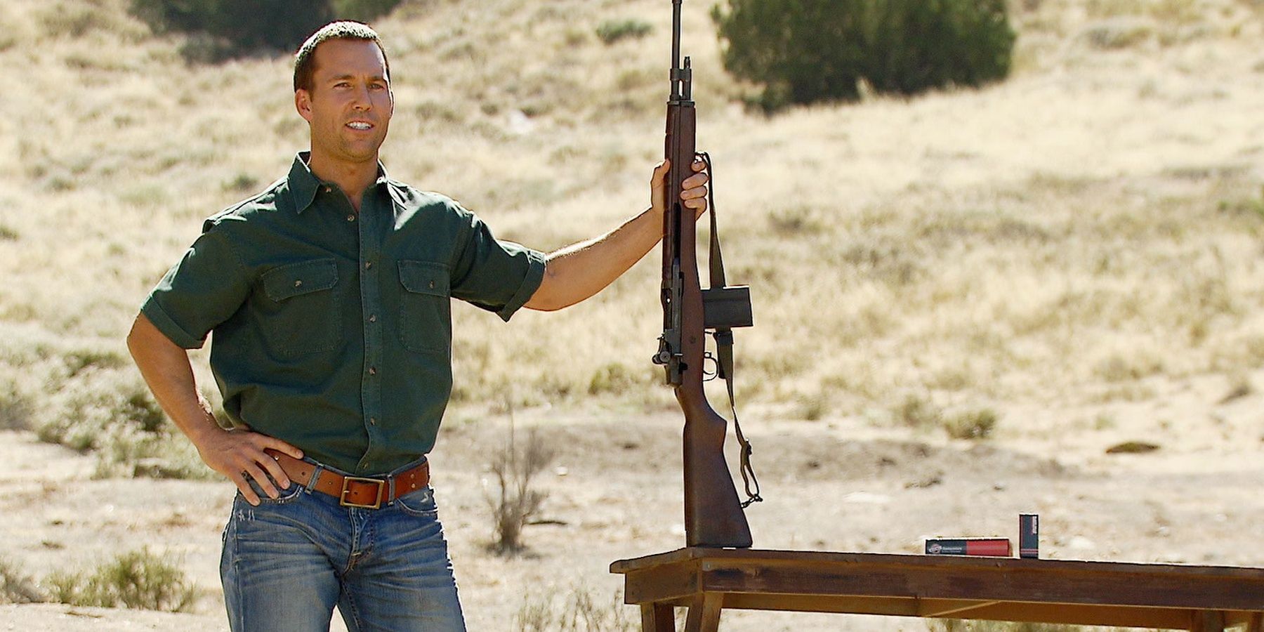 Colby Donaldson holding a rifle in a desert in a still from Top Shot