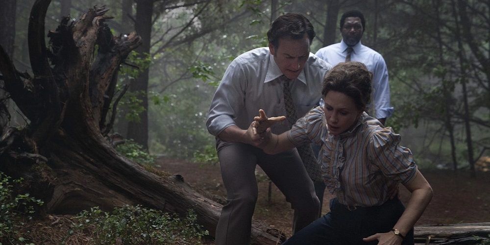 Ed holds Lorraine from falling in woods in The Conjuring 3.