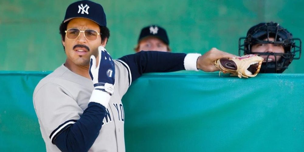 Daniel Sunjata standing against the boundary of a baseball field in a still from The Bronx is Burning