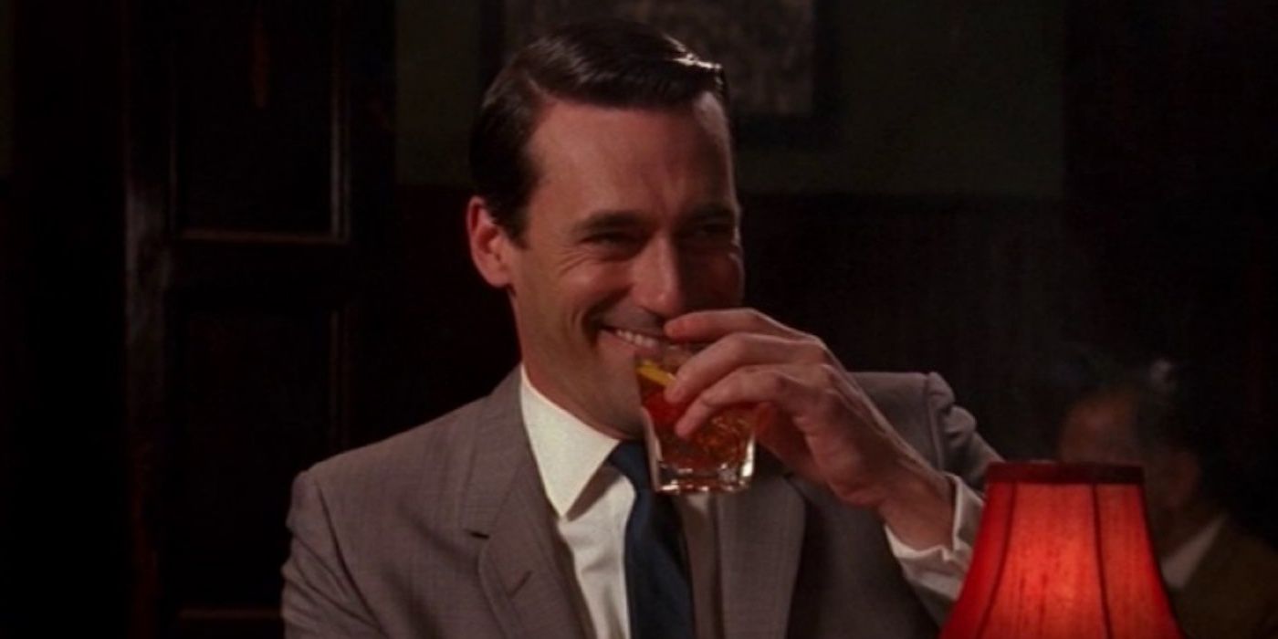 Don Draper laughing and having a drink in Mad Men.