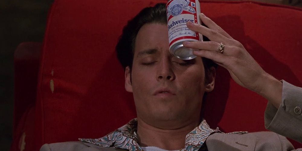 Johnny Depp as Donnie Brasco holding a cold can of beer to his head in Donnie Brasco
