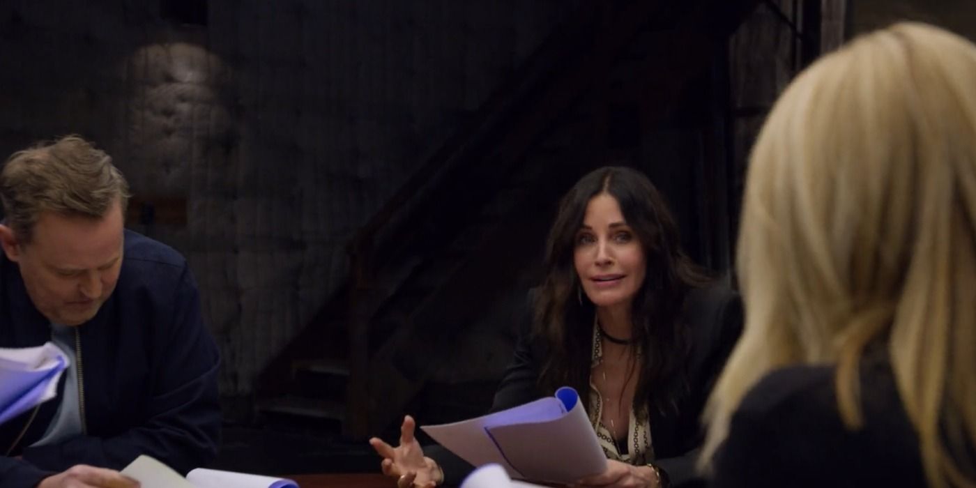 The cast sit at a table rereading scripts in Friends: The Reunion