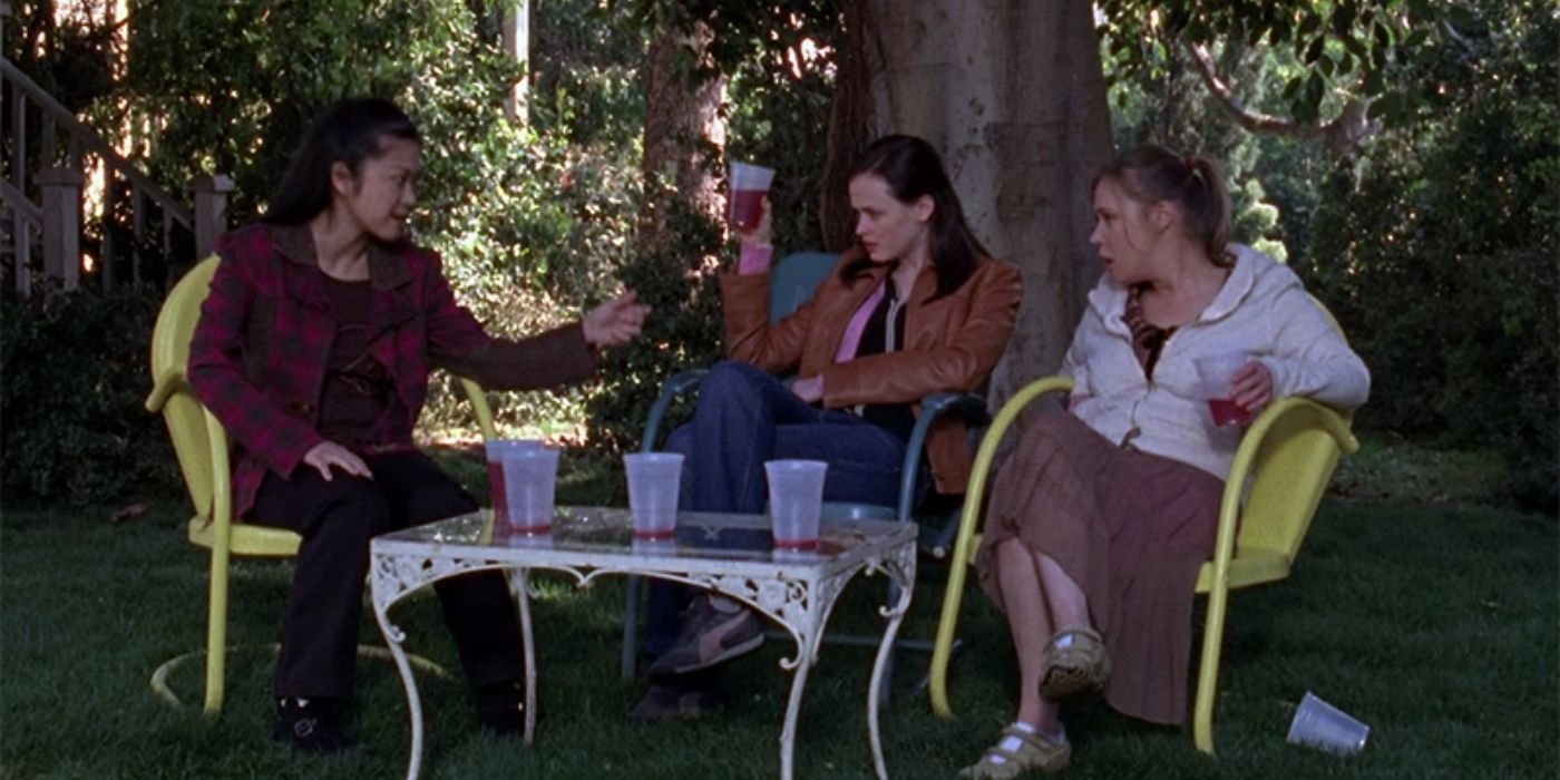 Lane, Rory, and Paris drinking Founder's Day punch outside at a table on Gilmore Girls