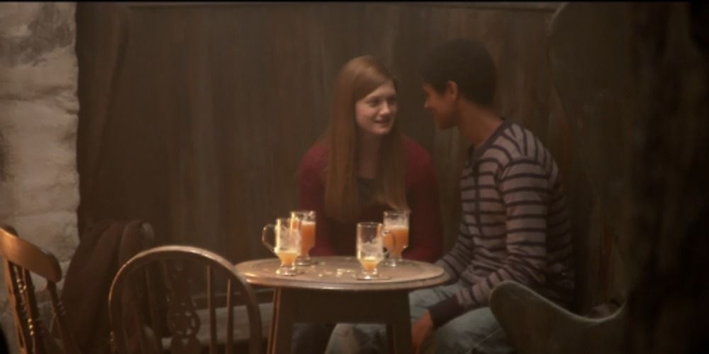 Ginny Weasley and Dean Thomas from Harry Potter sitting in a pub drinking butterbeer