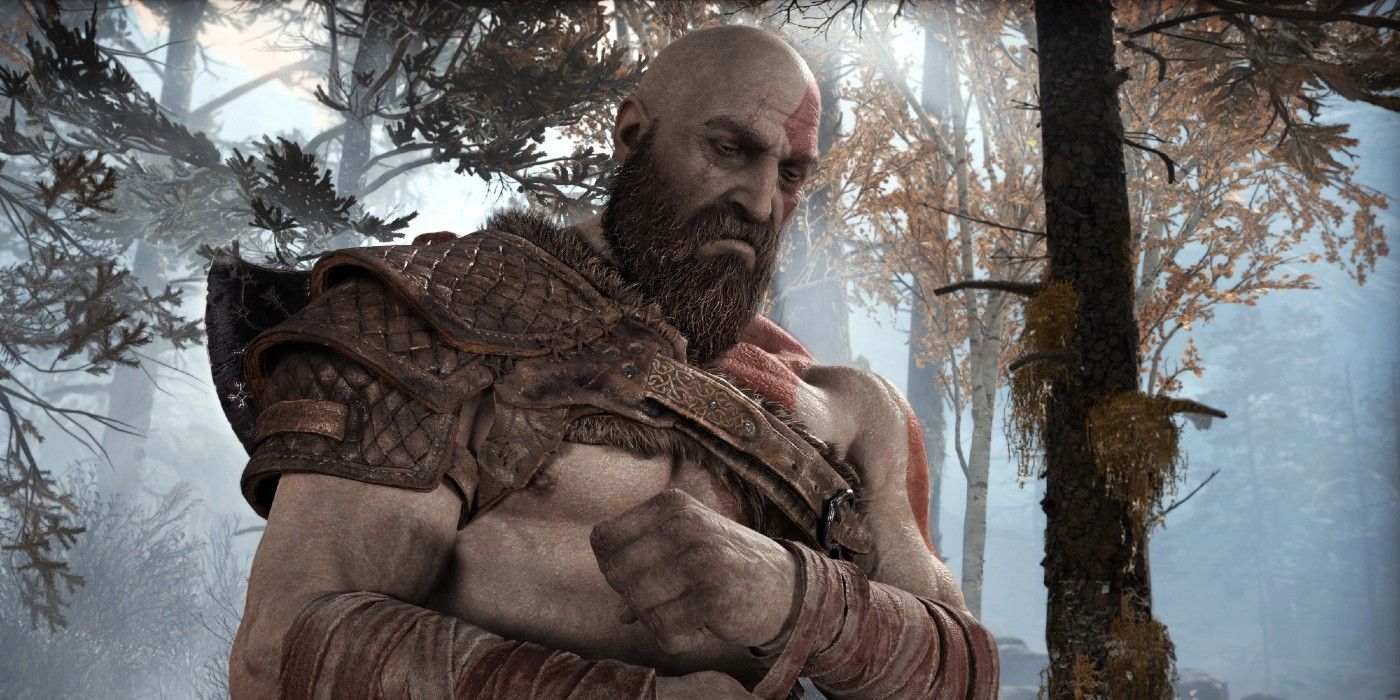 Kratos com a cabeça baixa parecendo triste em God of War