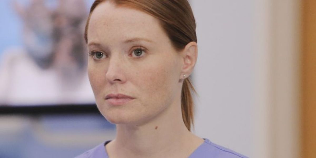 Penny in her scrubs looking serious in Grey's Anatomy