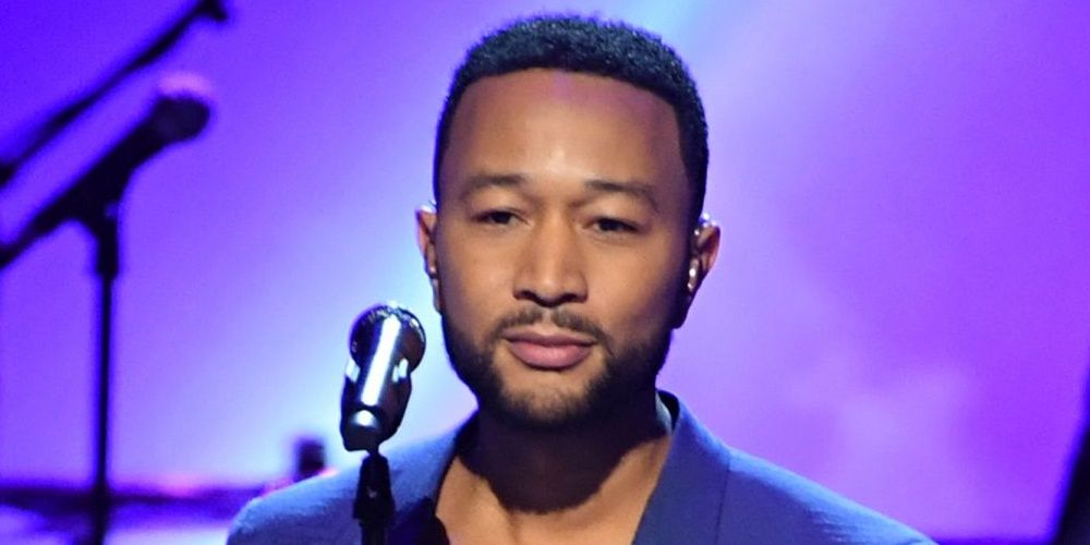John Legend standing in front of a microhpone