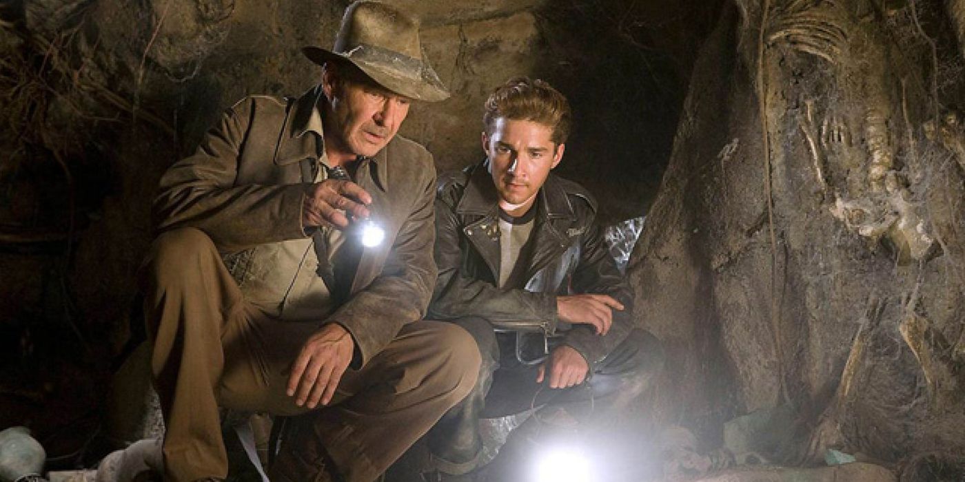 Indiana Jones et Mutt Williams examinent quelque chose sur le sol dans une grotte avec des lampes de poche.