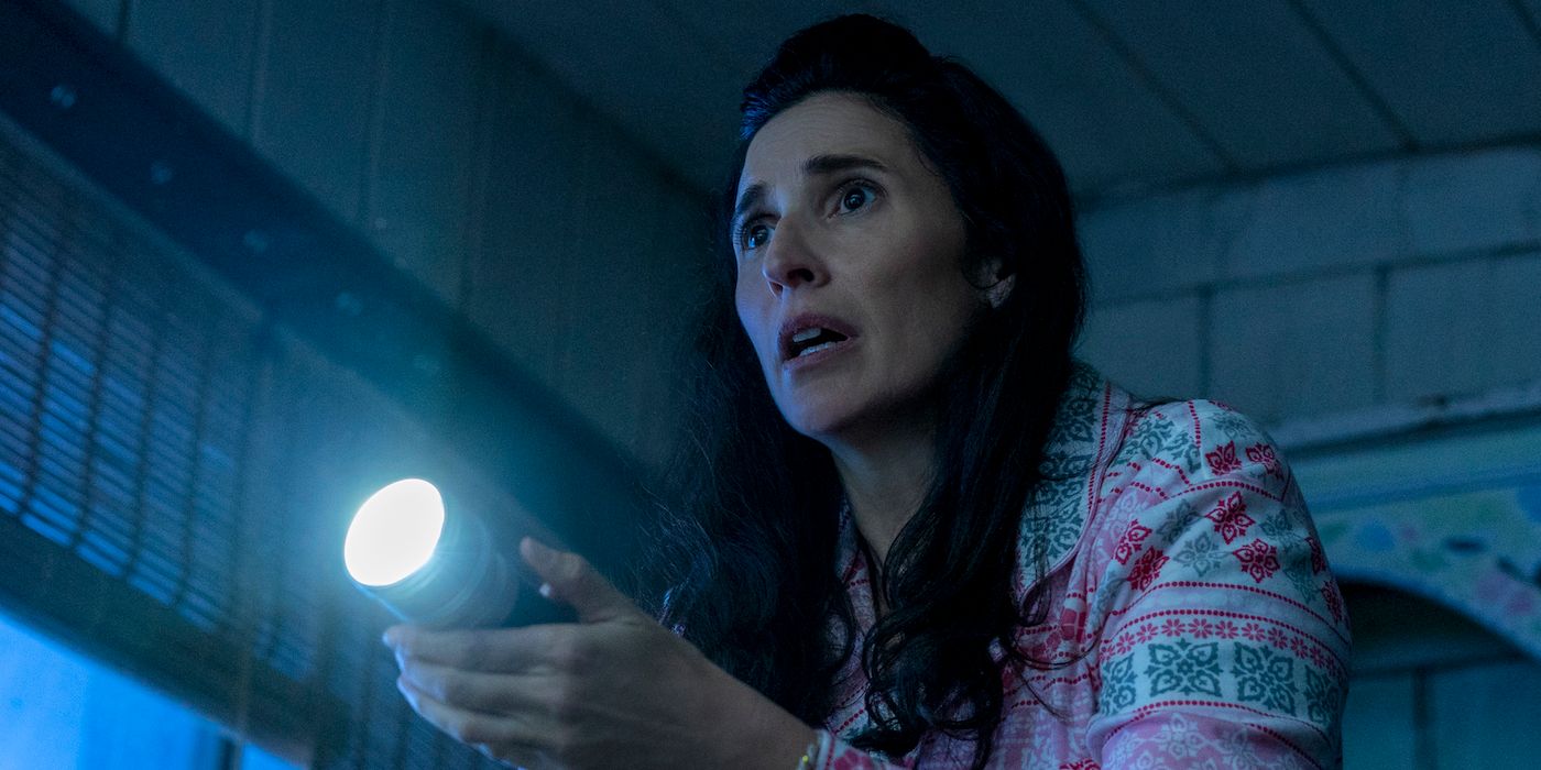 A scared young woman holding a flashlight in Werewolves Within