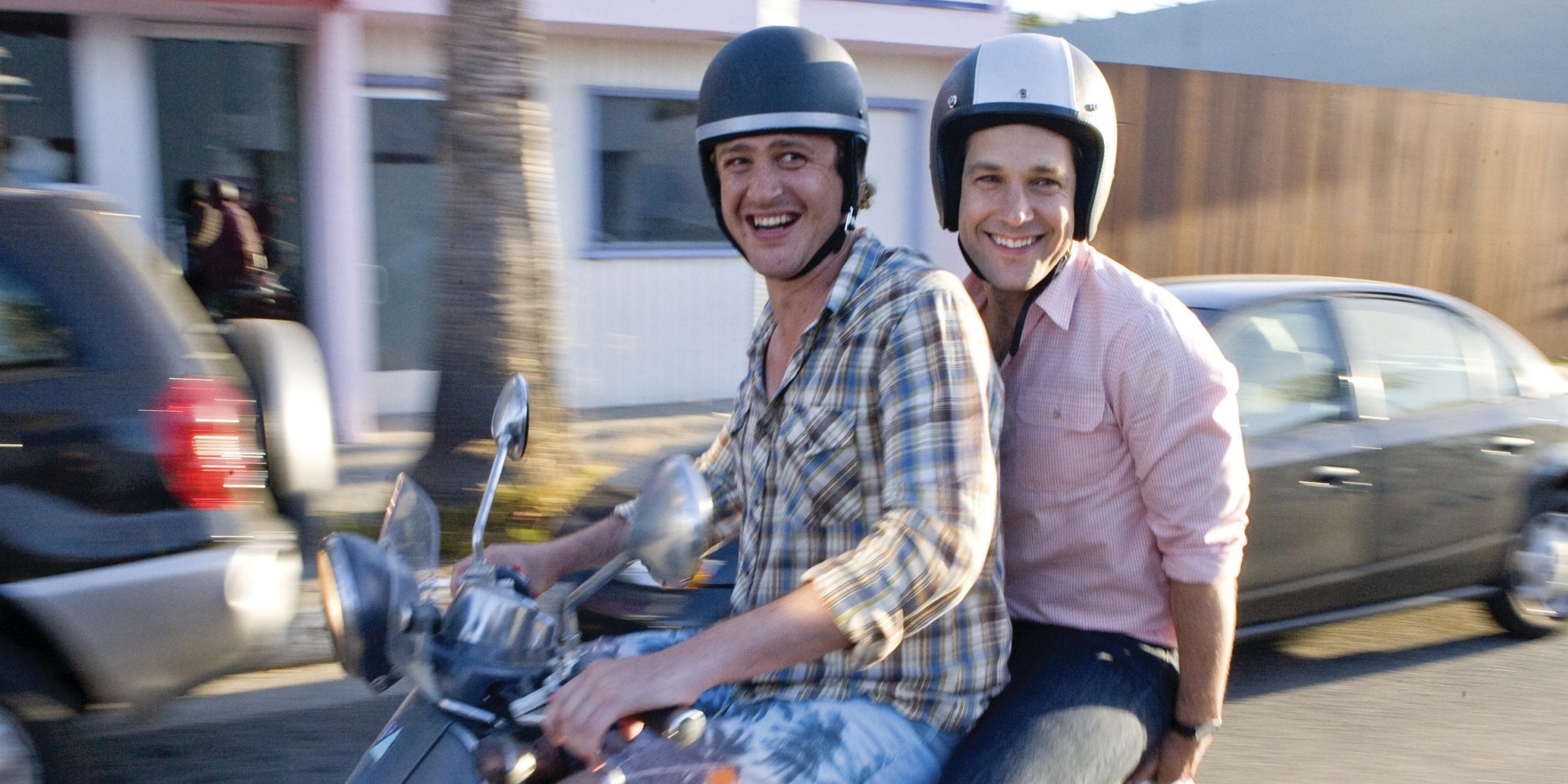 Paul Rudd and Jason Segel in I Love You, Man smiling while riding a Vespa together.