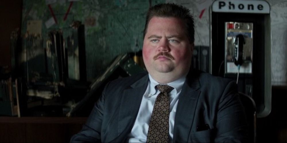 Paul Walter Hauser as Richard Jewell sat in an office wearing a suit