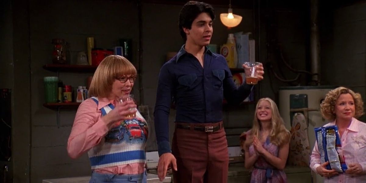Rhonda and Fez make a toast in the Foreman's basement