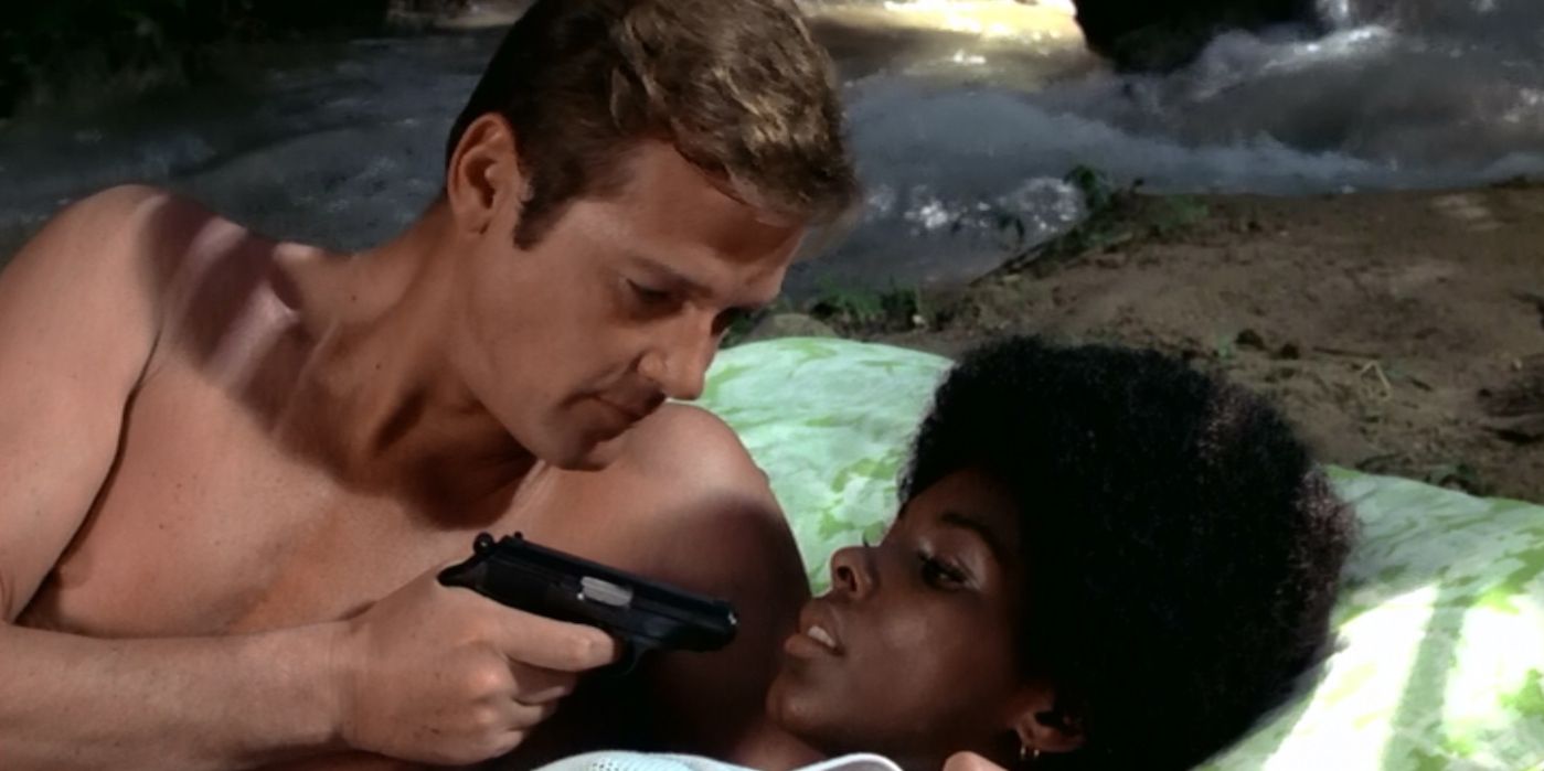 James Bond points a gun at Rosie Carver