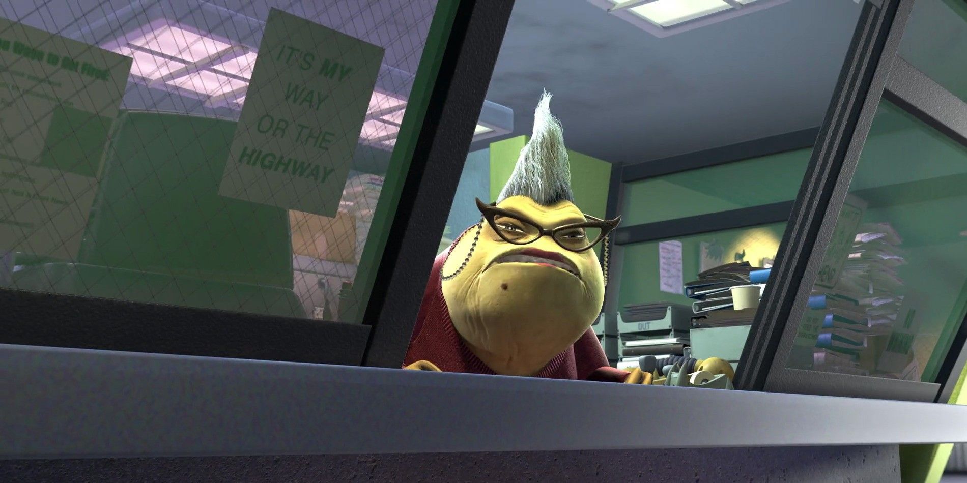 Roz gives a disgruntled look from behind her desk, while wearing her glasses