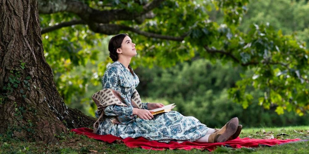 Emily Dickinson sits under a tree