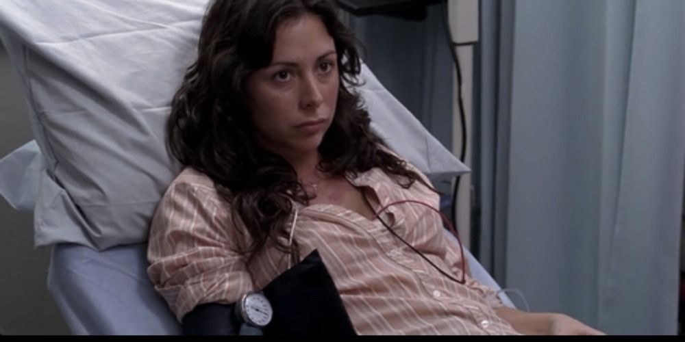 Patient Pamela Cavla looks on despondently as doctors speak to her in Grey's Anatomy.