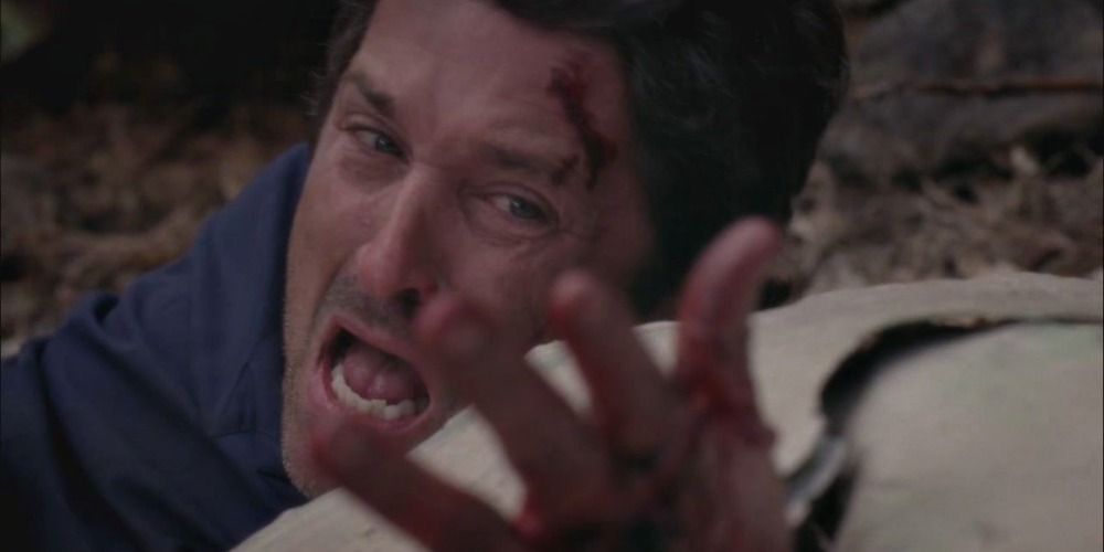 Dr. Derek Shepherd looks in agony at his mutilated hand he sustained in a plane crash in Grey's Anatomy.
