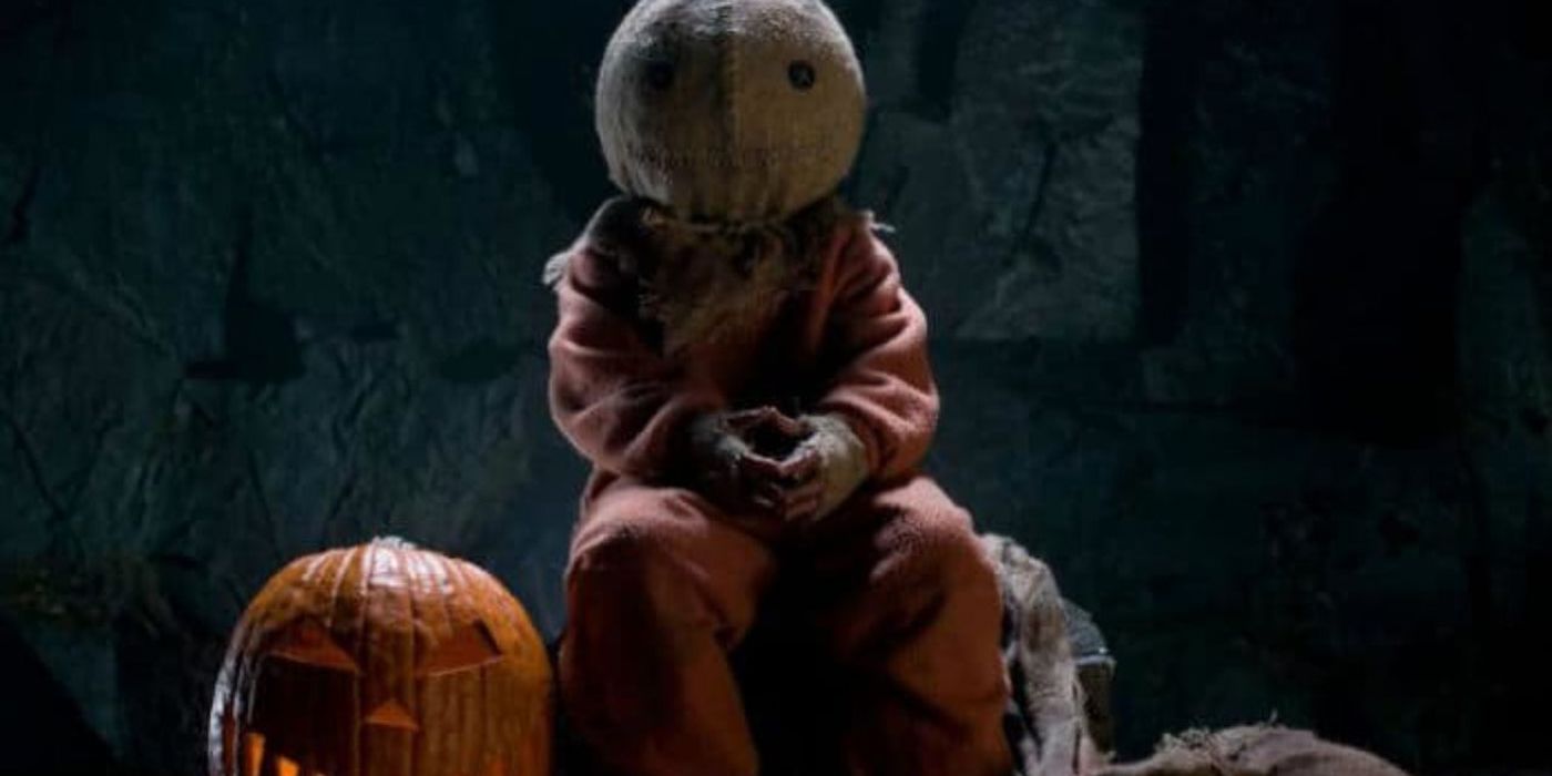 Sam sitting by a pumpkin in Trick r Treat