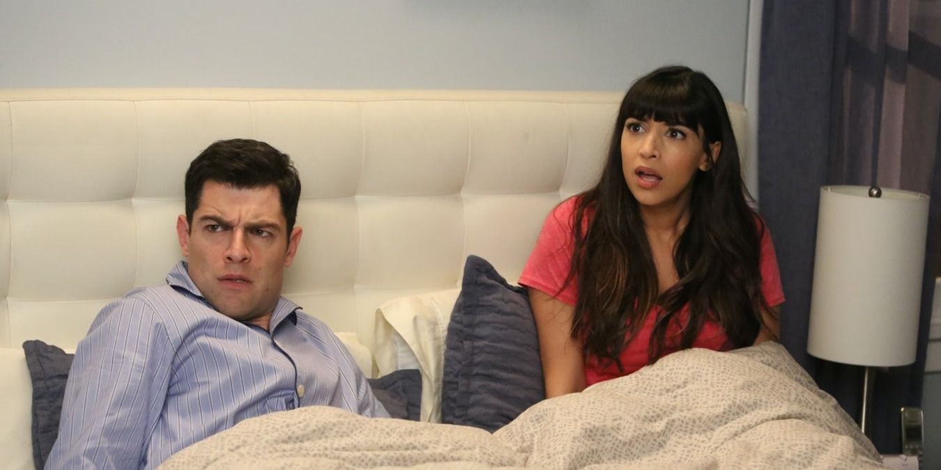 Schmidt and Cece in their bed, looking over confused and startled