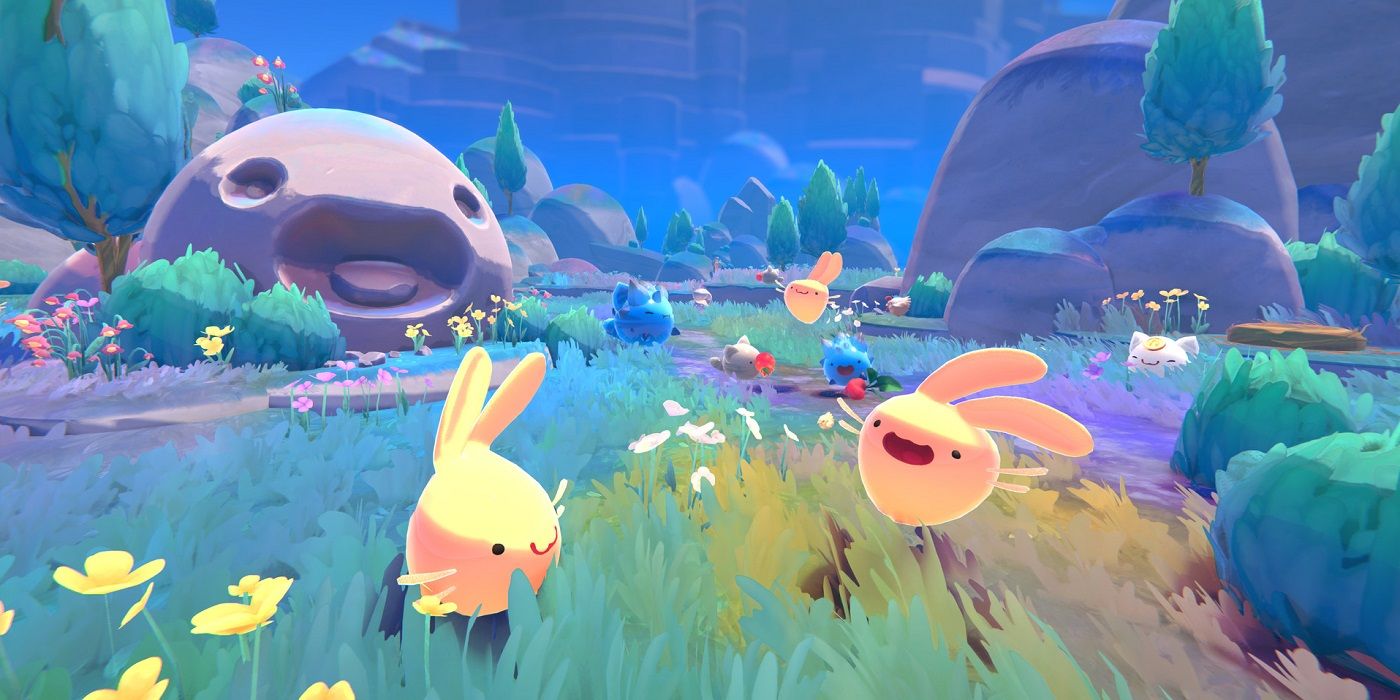 Creatures frolic in a field in Slime Rancher 2