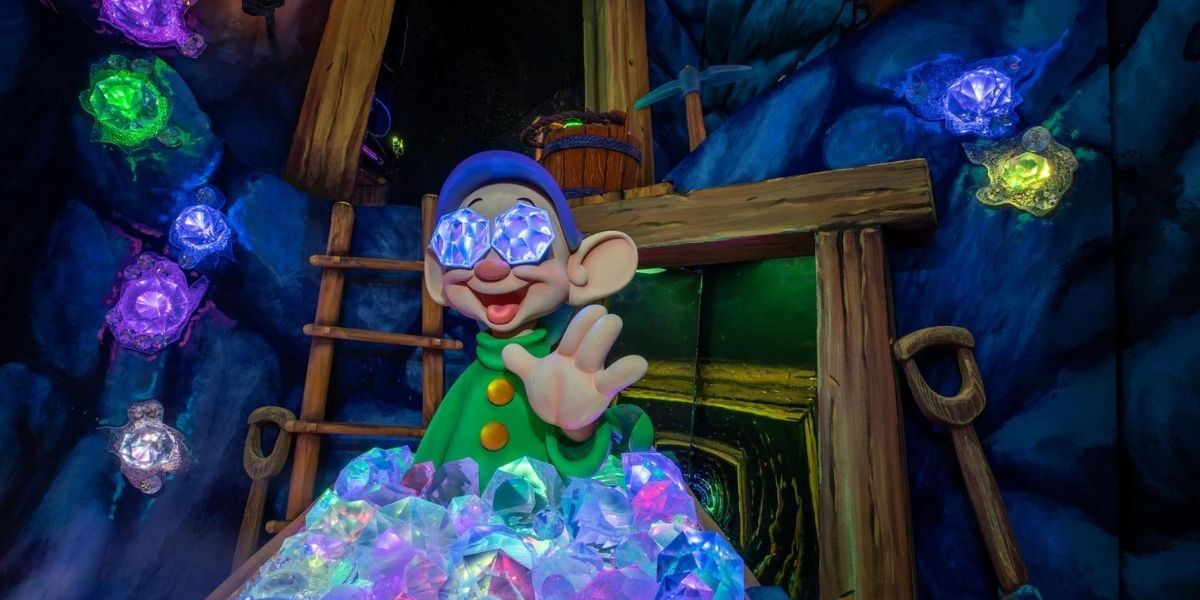 Dopey dawrf with two jewels in his eyes, waving hello at Snow White's Enchanted Wish ride at Disneyland