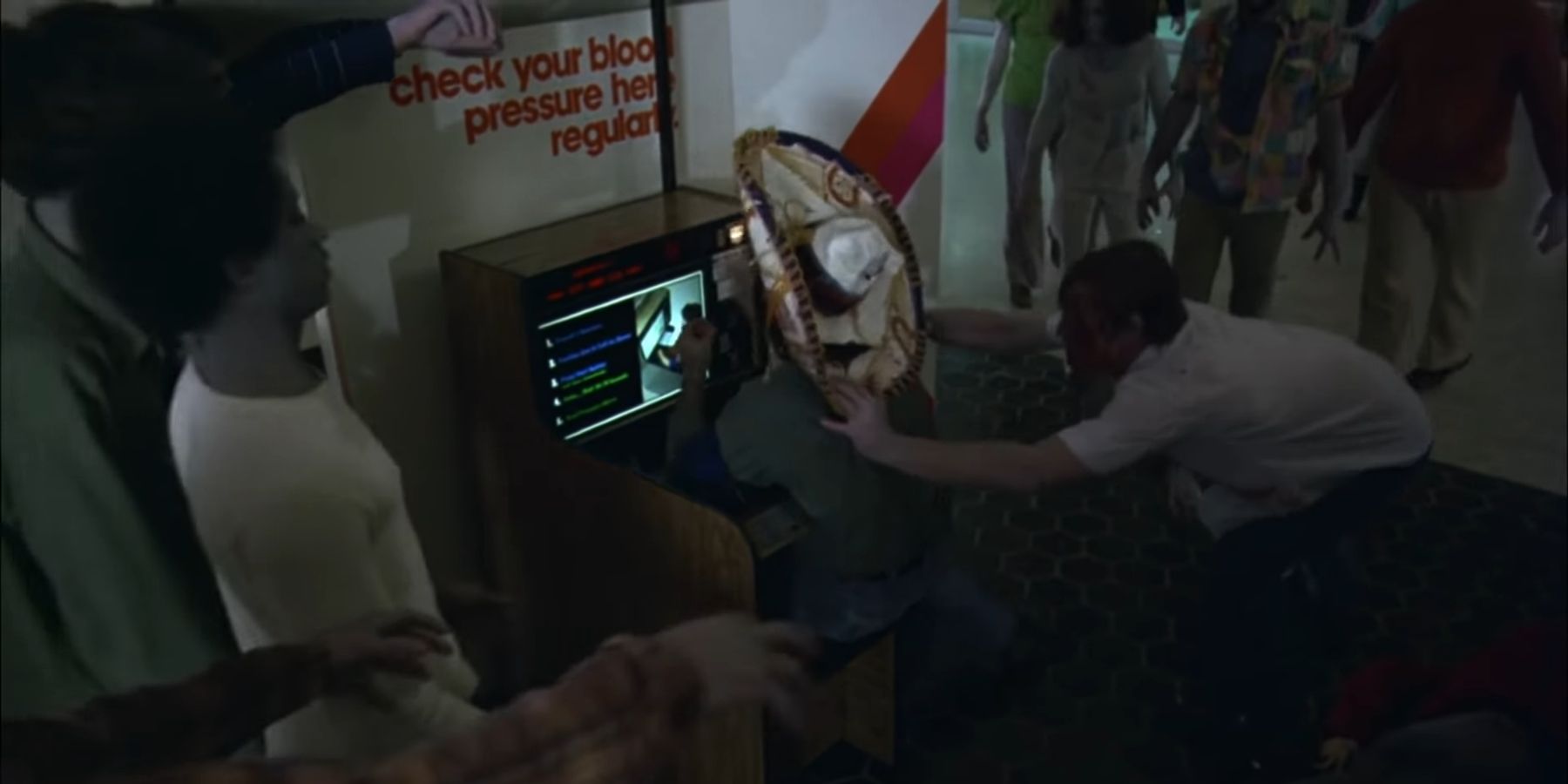 Sombrero biker being attacked by zombies at blood pressure machine in Dawn Of The Dead