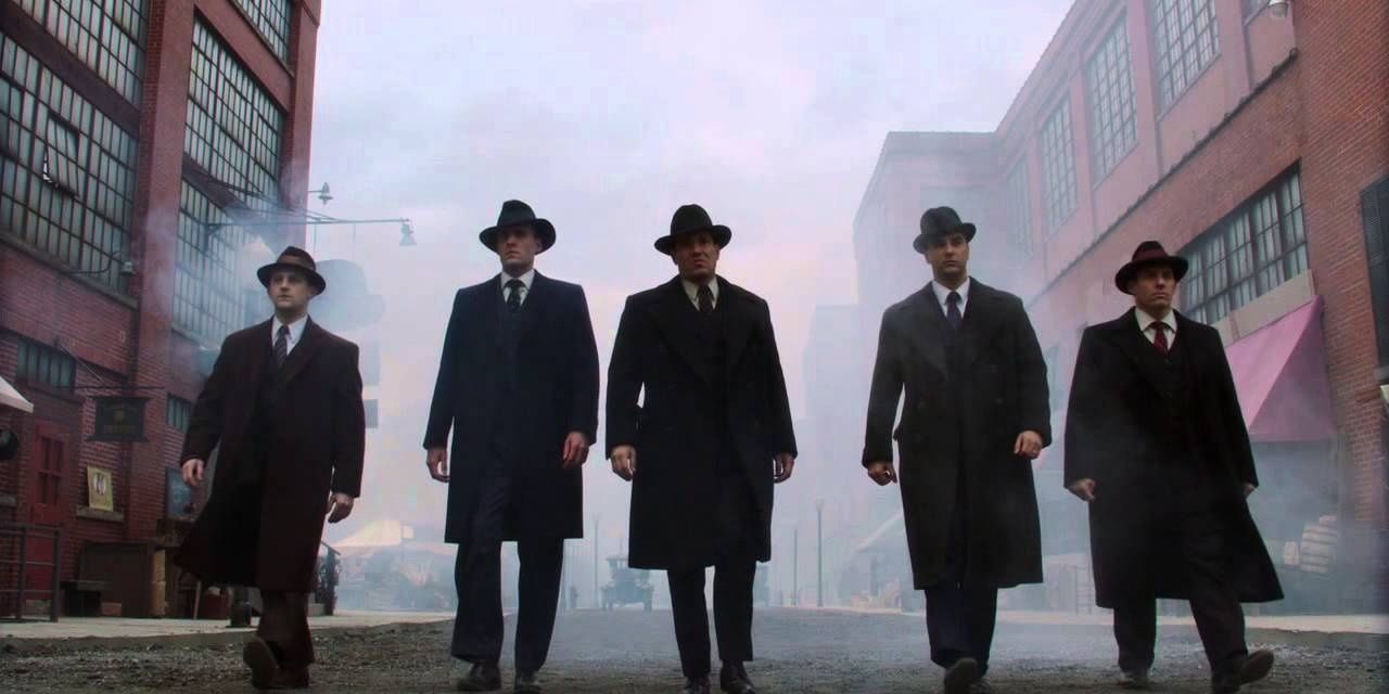 The cast of The Making of the Mob walks down the street in suits