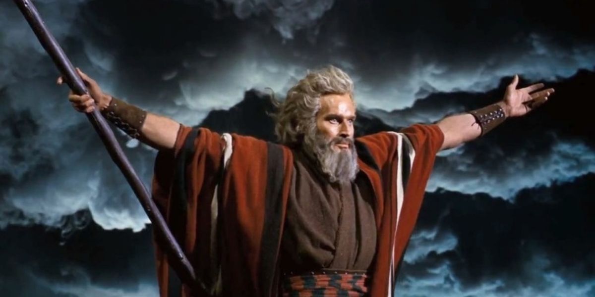Moses holding a staff and raising his arms in The Ten Commandments.