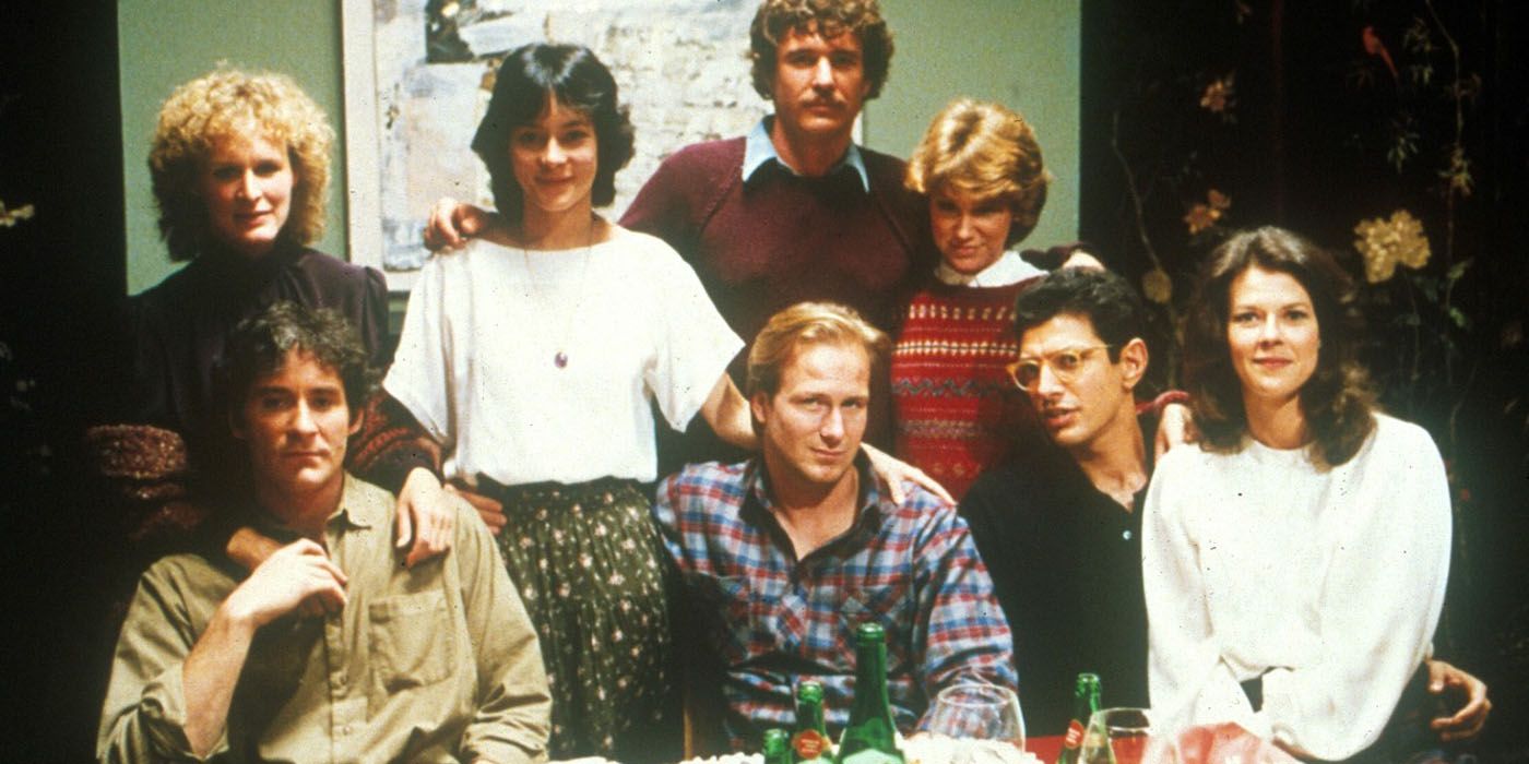 The cast of The Big Chill posing at a table.