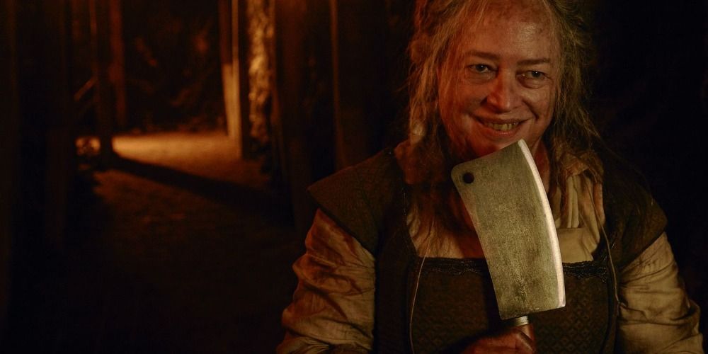 Thomasin White smiling with a butcher knife in her hand in AHS.