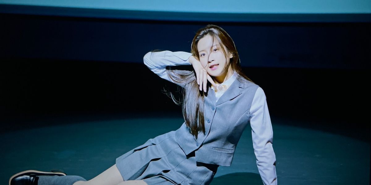 Joo-Kyung in school uniform striking a pose on the floor in True Beauty