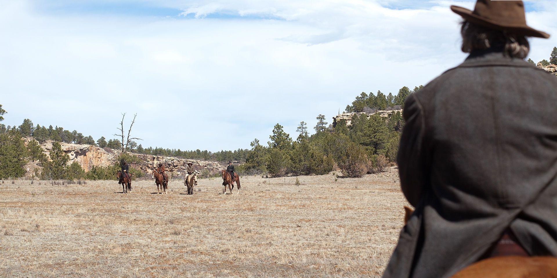 A rider stares down cowboys in True Grit