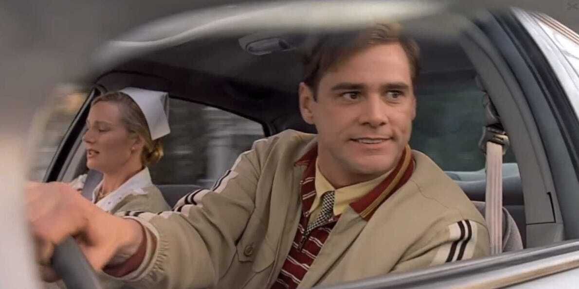 Truman steers the car as he attempts to escape Seahaven, and Meryl is scared in the passenger seat, in The Truman Show