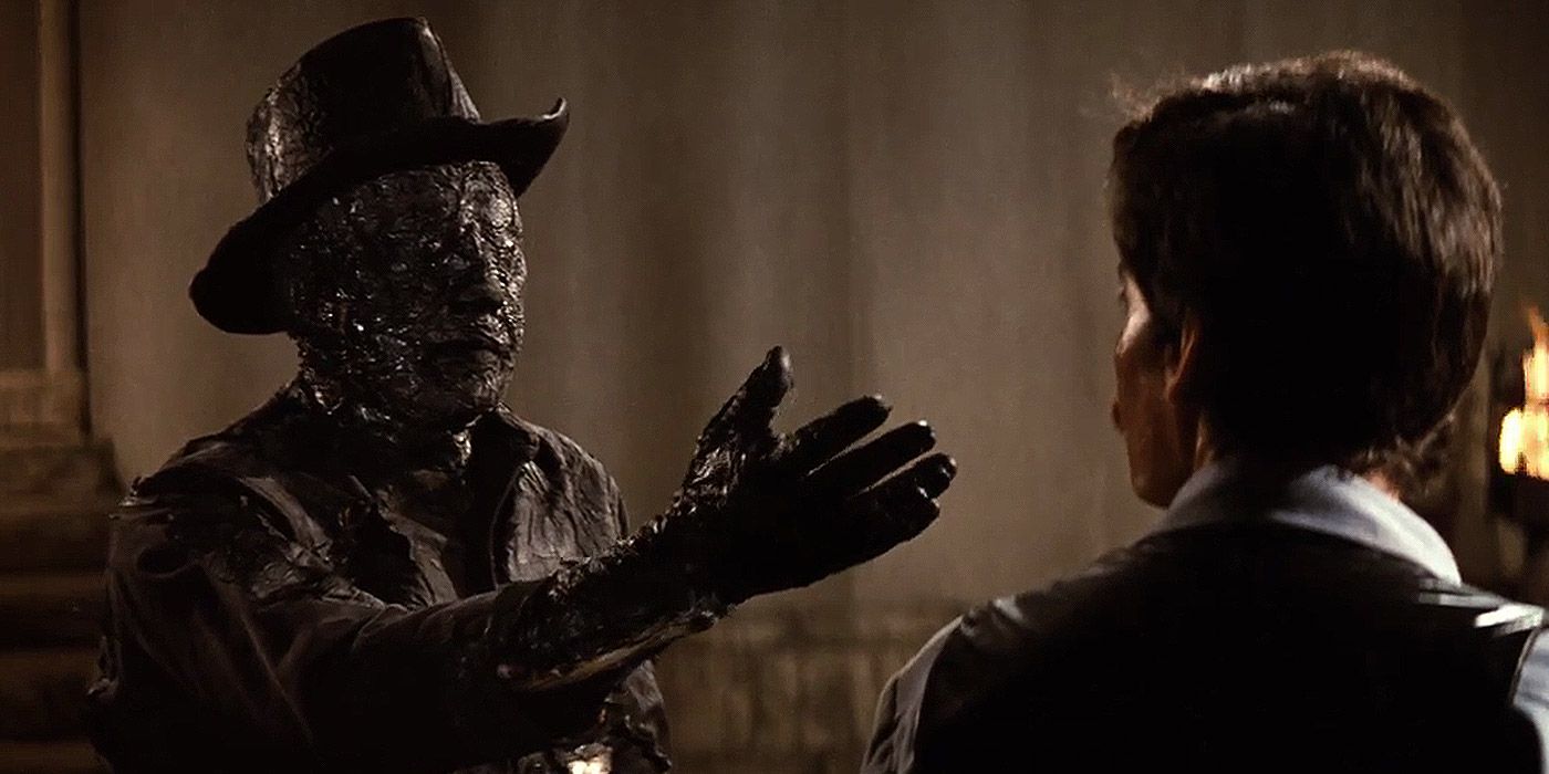 A burnt Gunslinger reaches for Peter Martin in Westworld