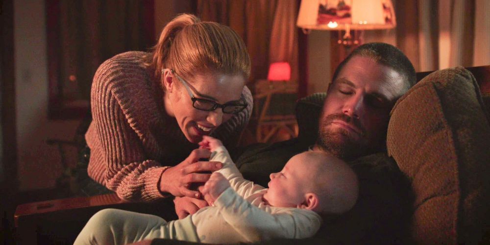 Oliver, Felicity, and Mia cuddling on the couch in Arrow