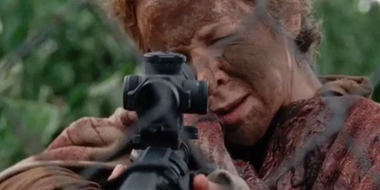 Carol covered in mud and blood aims gun in The Walking Dead