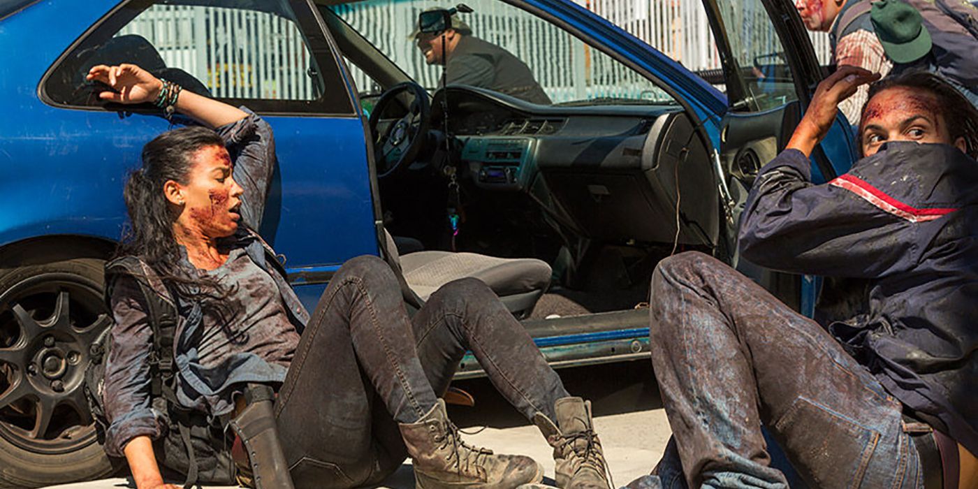 Luciana and Nick hiding behind a car, bloody and hurt, on Fear the Walking Dead