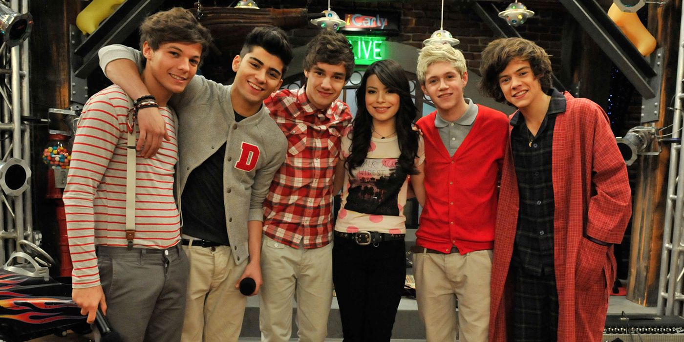 Miranda Cosgrove posing with One Direction on the set of iCarly