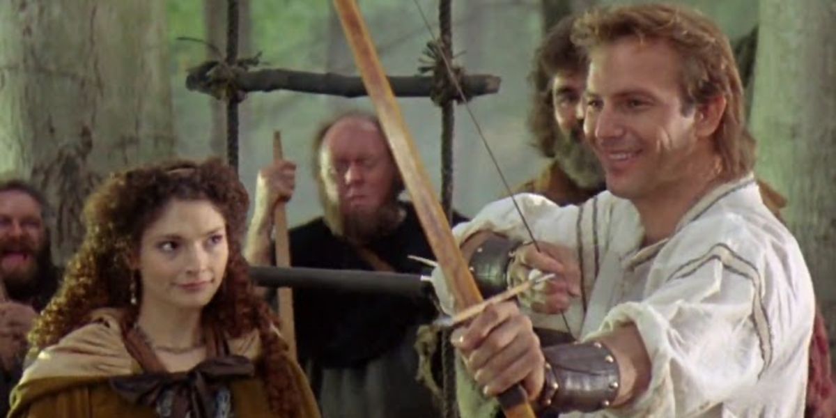 Lady Marian (Mary Elizabeth Mastrantonio) watching Robin Hood (Kevin Costner) try to shoot his bow in Robin Hood: Prince of Thieves