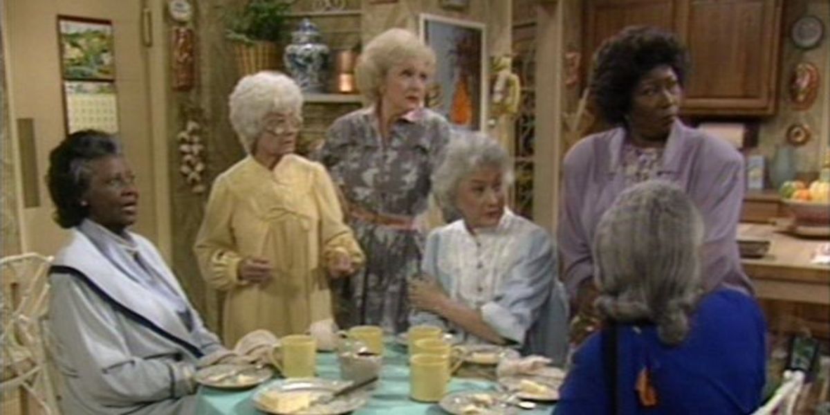 Blanche, Dorothy, Rose, and Sophia have cheese cake in the kitchen with Lorraine's family