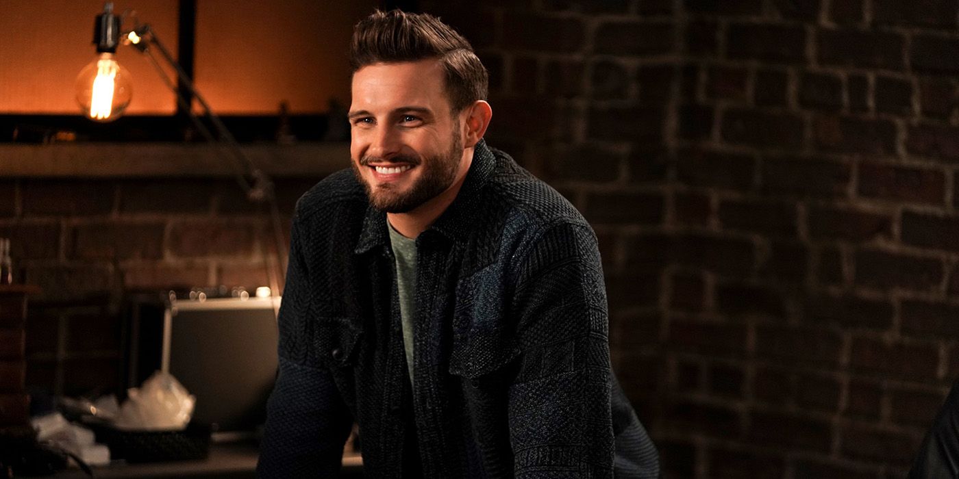 Josh standing behind the bar on Younger, smiling widely