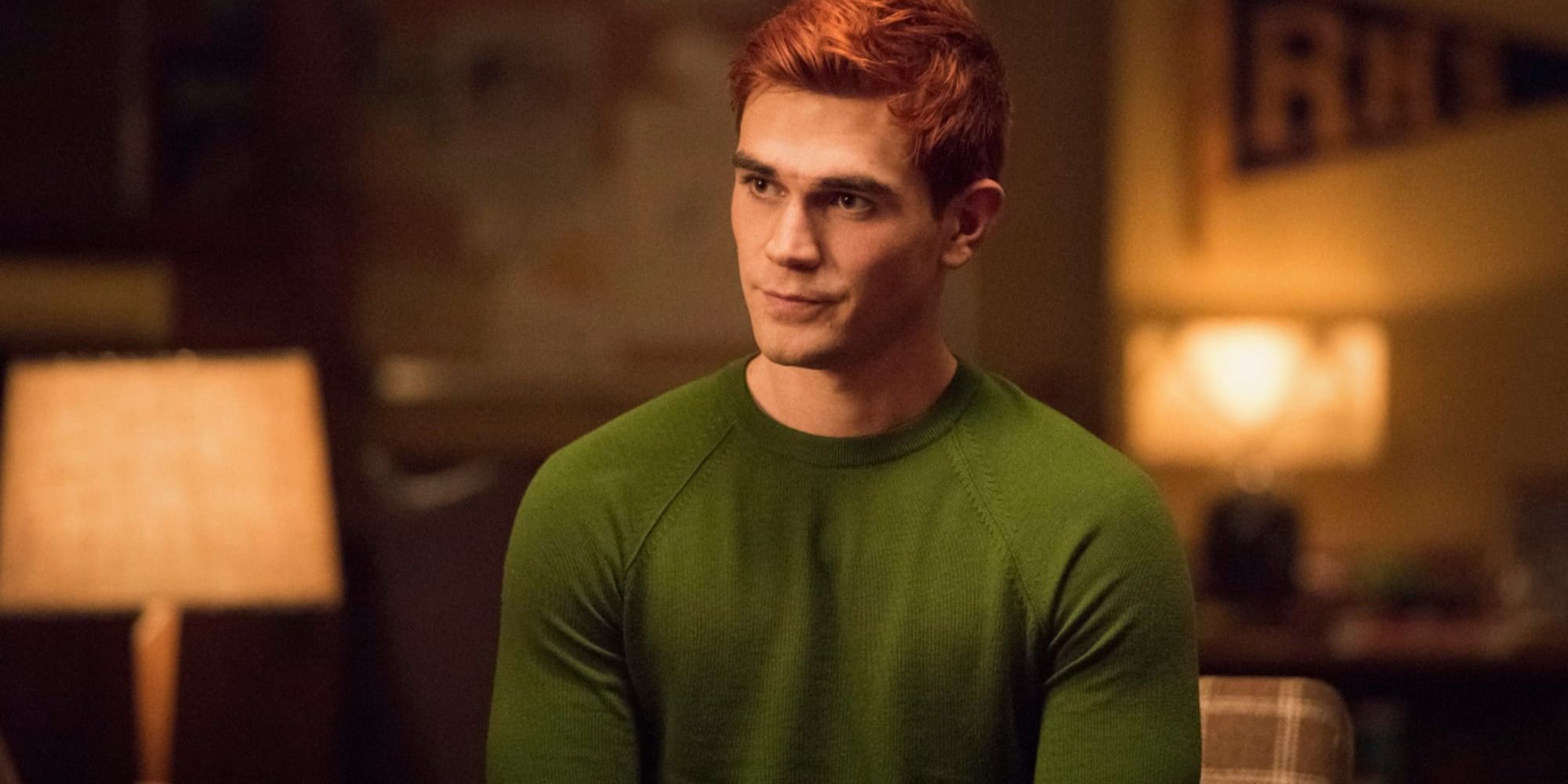 Archie looks on while wearing a green sweater in Riverdale.