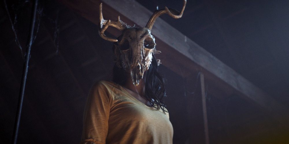 A woman wearing a skull in a still from The Wretched Cropped