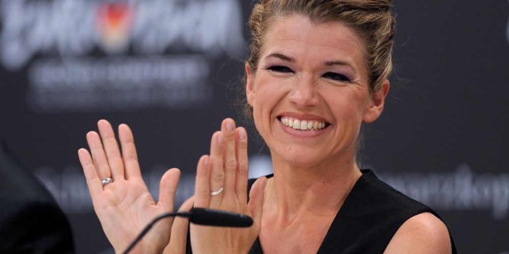 Anke Engelke smiling and clapping at an interview for Eurovision