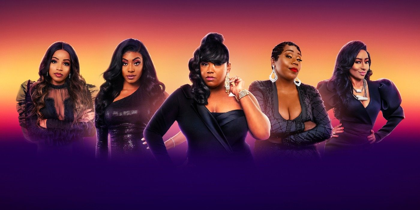 This is a cast photo of OWN's 'Belle Collective,' where the women are posing and wearing black in front of an orange and purple backdrop.