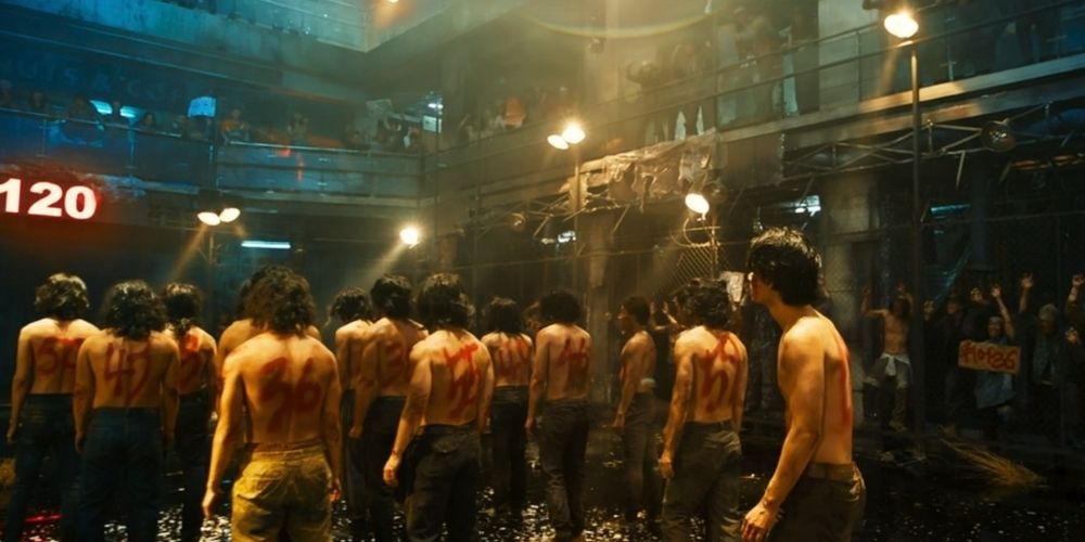 A group of men with numbers sprayed on their bodies go to the fight ring