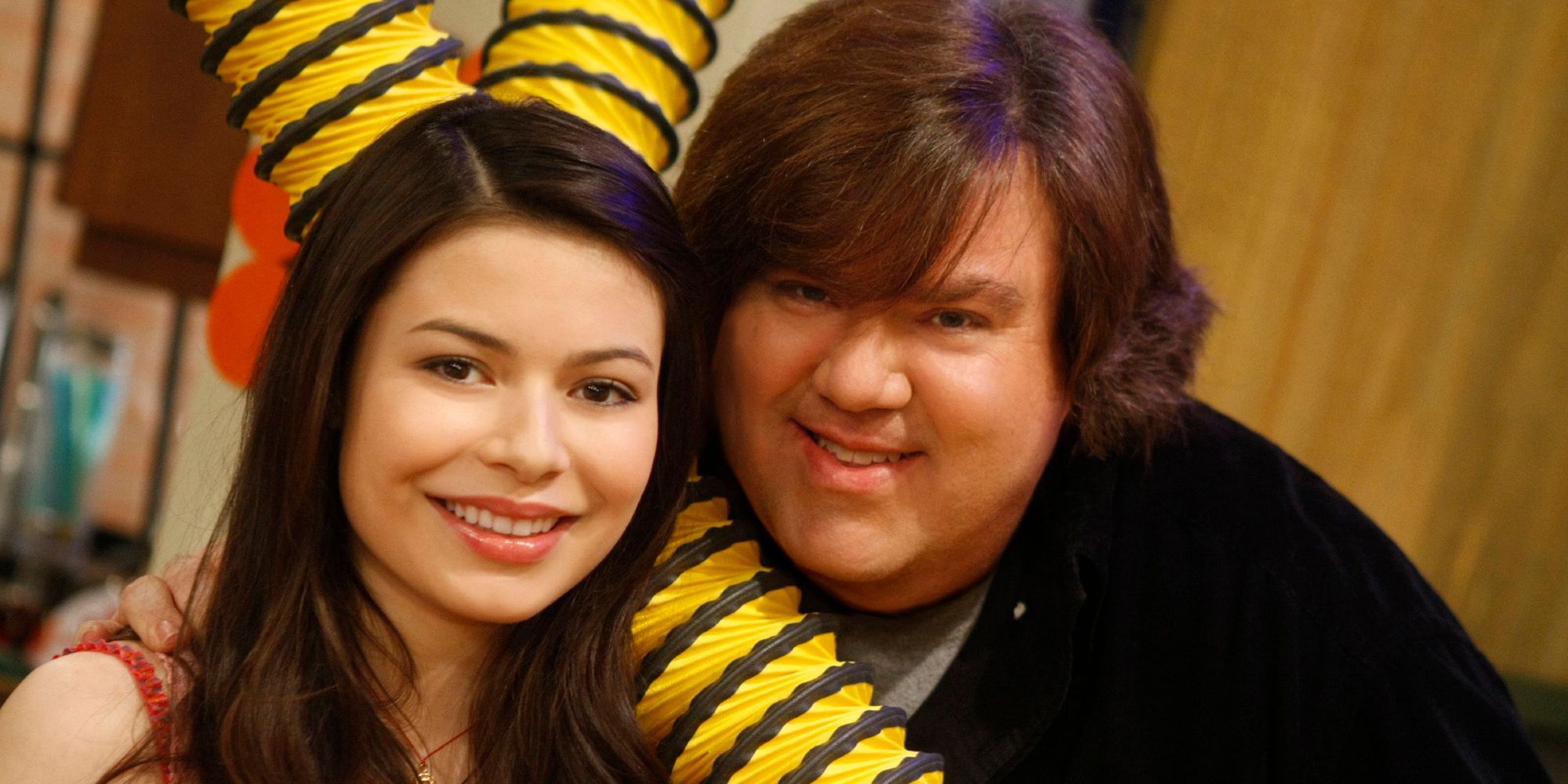 Miranda Cosgrove and Dan Schneider smiling on the set of iCarly